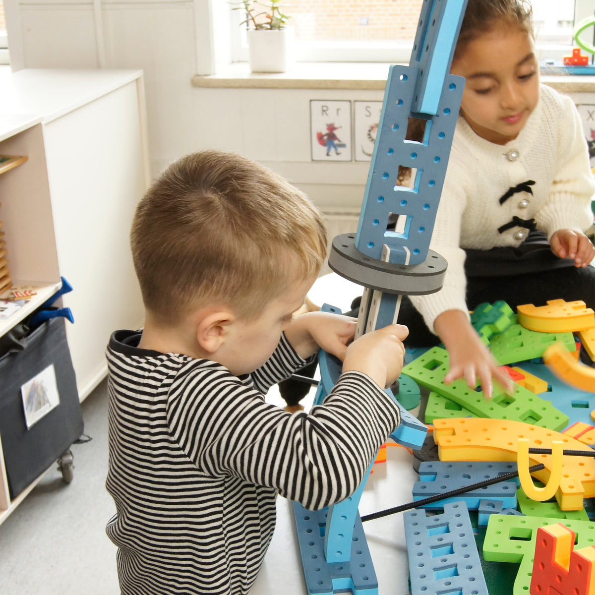 Kindergarten students practicing structural building techniques with large modular BAKOBA foam STEM blocks.