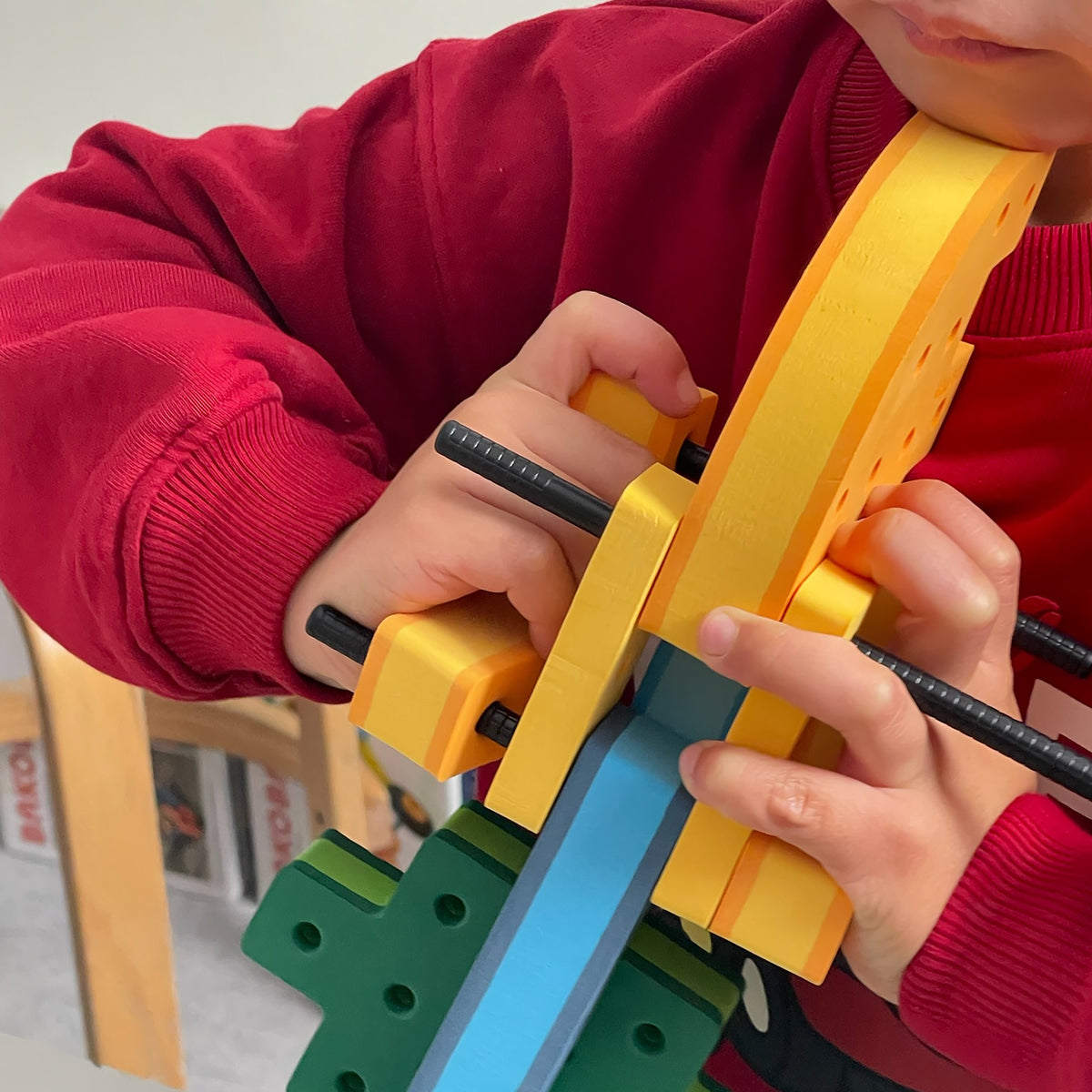 A student demonstrating the fine motor mechanics of connecting modular parts using a BAKOBA STEM toy kit